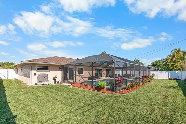 back of property featuring a fenced in pool, a lanai, and a lawn