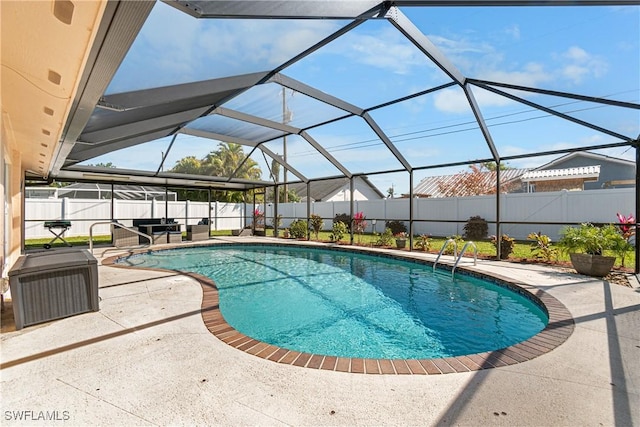 view of pool with a patio area and glass enclosure