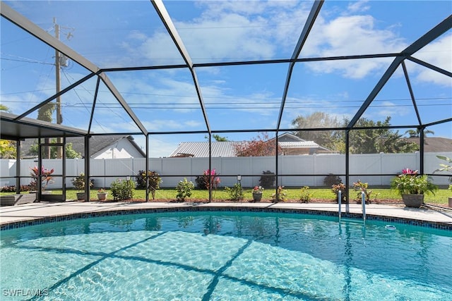 view of swimming pool featuring glass enclosure