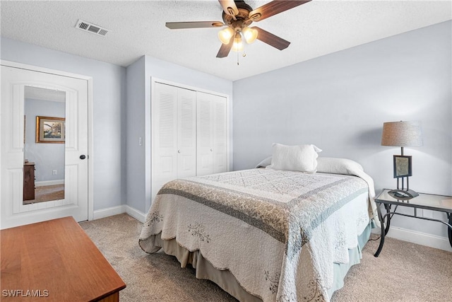 carpeted bedroom featuring ceiling fan, a closet, and a textured ceiling