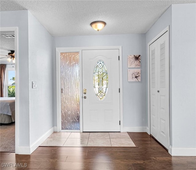 entrance foyer with ceiling fan, hardwood / wood-style floors, and a textured ceiling