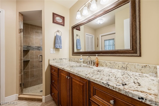 bathroom with vanity and a shower with shower door