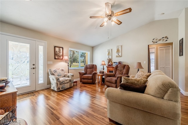 living room with ceiling fan, lofted ceiling, and light hardwood / wood-style floors