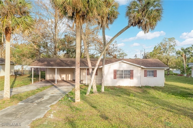 ranch-style home featuring a carport and a front lawn