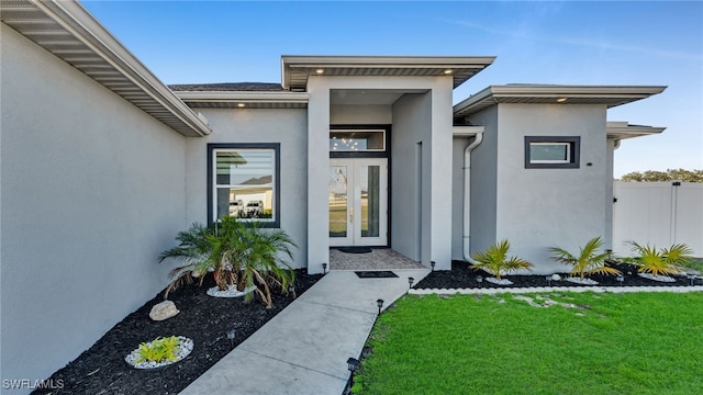 property entrance featuring a yard and french doors