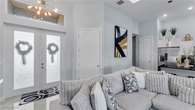 living room with french doors and a chandelier