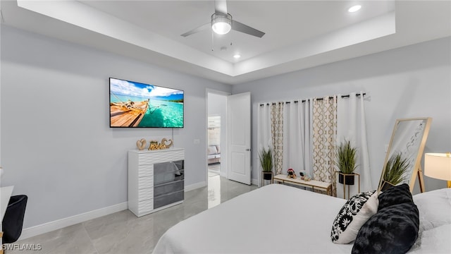 bedroom with ceiling fan and a raised ceiling