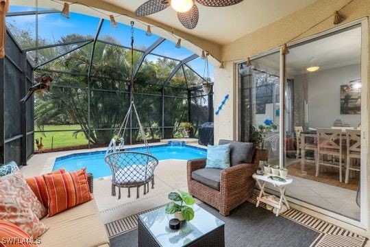 view of swimming pool featuring ceiling fan, outdoor lounge area, a patio area, and glass enclosure