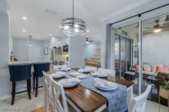 tiled dining room with ornamental molding and ceiling fan