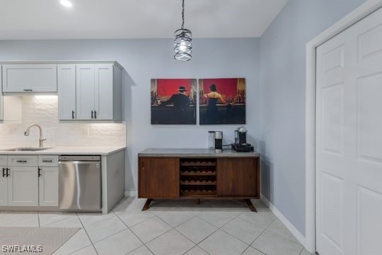 bar featuring sink, tasteful backsplash, decorative light fixtures, stainless steel dishwasher, and white cabinets