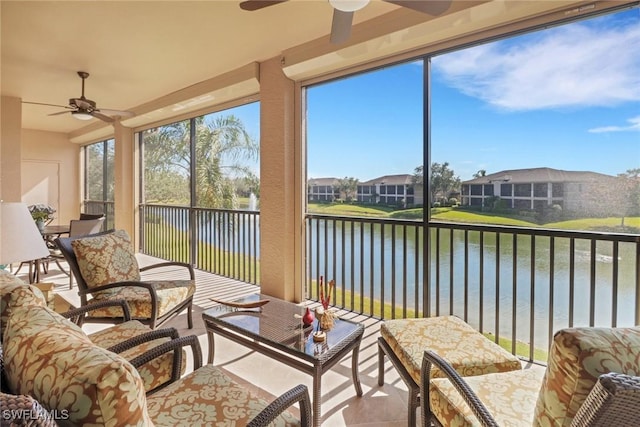 sunroom / solarium featuring a water view and ceiling fan