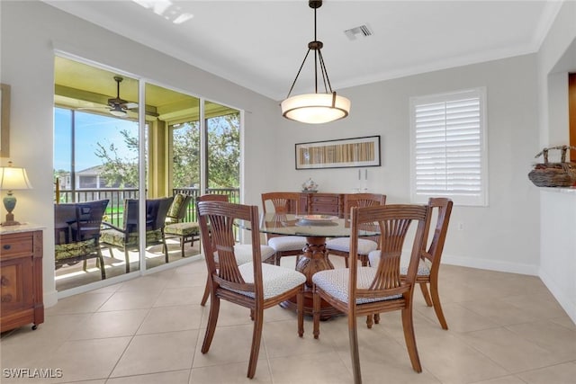 tiled dining room featuring ornamental molding