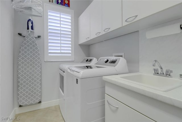 washroom featuring cabinets, sink, washer and dryer, and light tile patterned floors