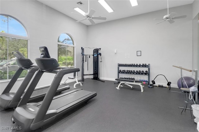 exercise room with a high ceiling and ceiling fan