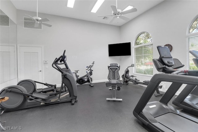 workout area with a towering ceiling and ceiling fan