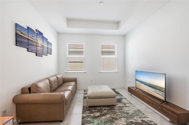 tiled living room featuring a tray ceiling