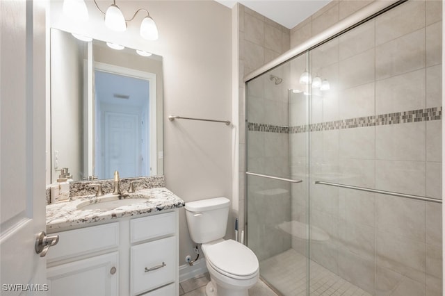 bathroom featuring vanity, toilet, and a shower with door