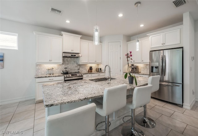 kitchen featuring stainless steel appliances, sink, a center island with sink, and decorative light fixtures