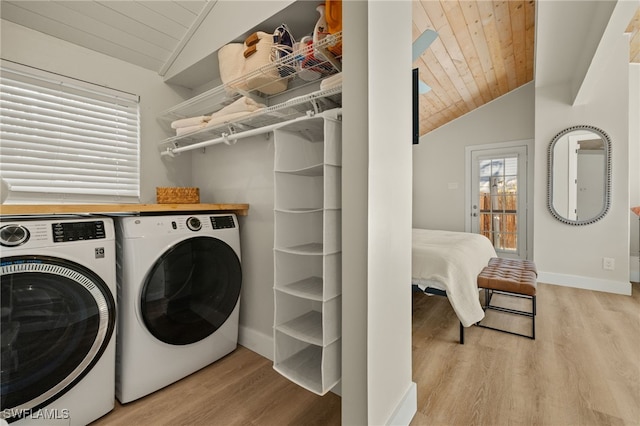 clothes washing area with wood ceiling, washing machine and dryer, and light wood-type flooring