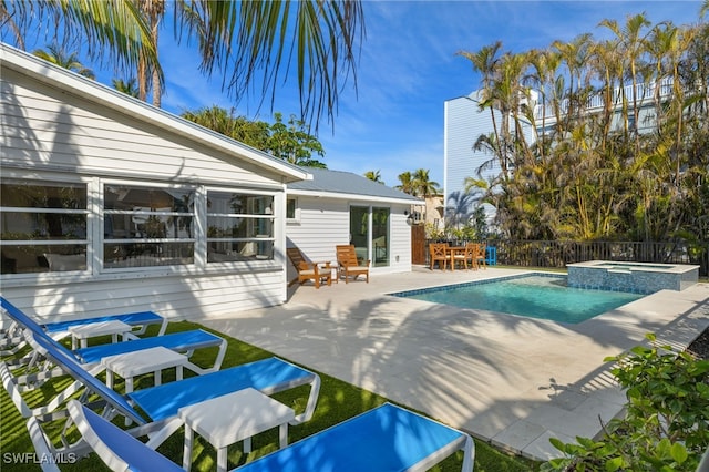 view of pool with a patio area and an in ground hot tub