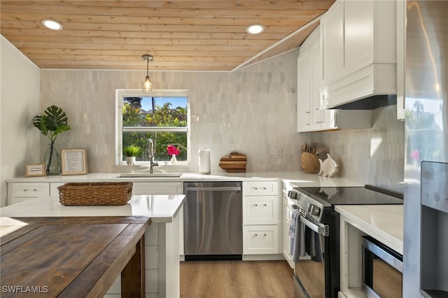 kitchen with white cabinetry, sink, decorative light fixtures, and appliances with stainless steel finishes