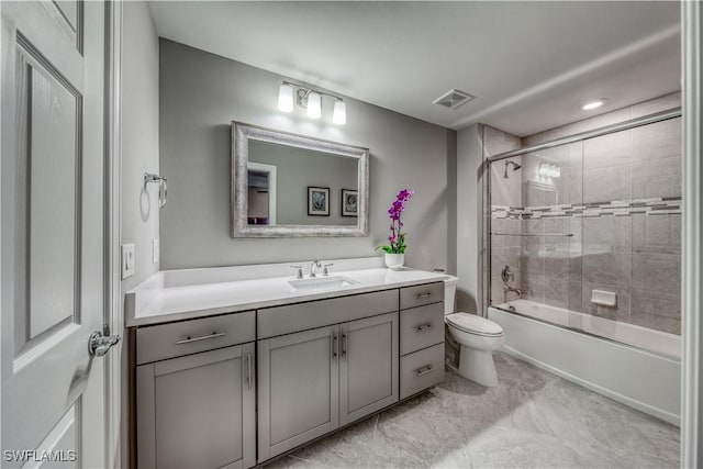 full bathroom with enclosed tub / shower combo, vanity, and toilet