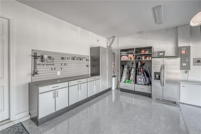 garage featuring stainless steel fridge and electric panel