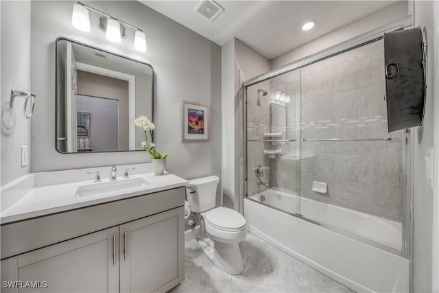 full bathroom featuring vanity, bath / shower combo with glass door, and toilet