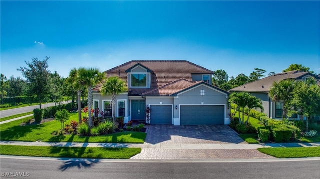 view of front of home featuring a tiled roof, an attached garage, decorative driveway, a front yard, and stucco siding