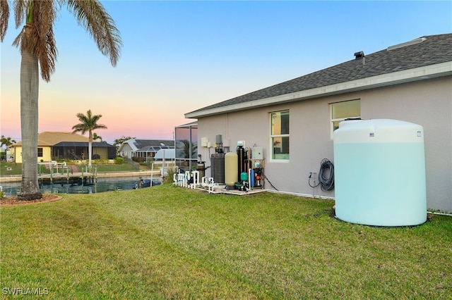 yard at dusk featuring a water view