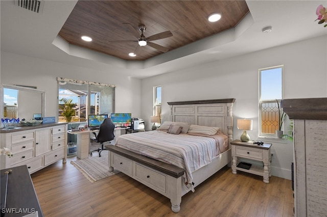 bedroom with light hardwood / wood-style flooring, wooden ceiling, a raised ceiling, and ceiling fan