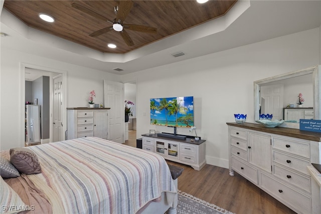 bedroom with dark hardwood / wood-style flooring, wood ceiling, and a raised ceiling