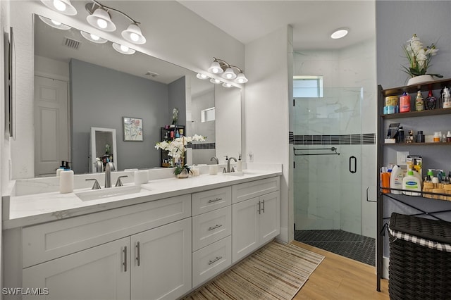 bathroom featuring hardwood / wood-style flooring, vanity, and a shower with door