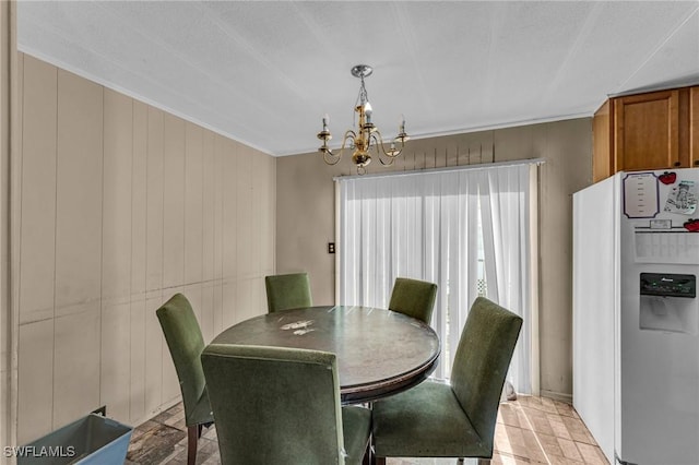 dining room with an inviting chandelier and wood walls