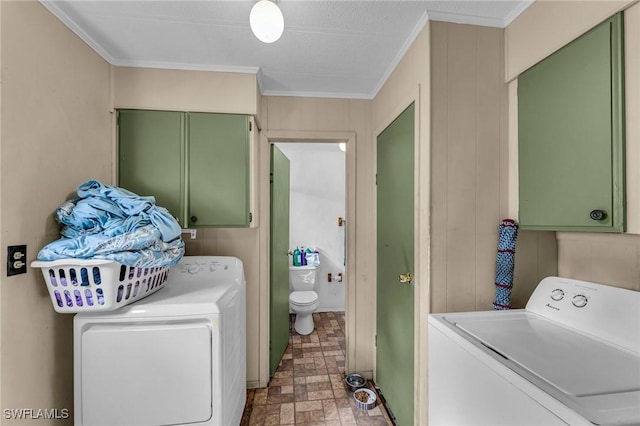 laundry room with crown molding, cabinets, and washer and clothes dryer