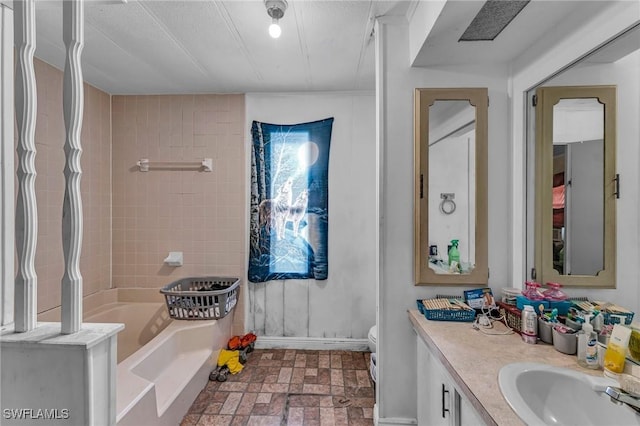 bathroom featuring vanity, a bathtub, and toilet