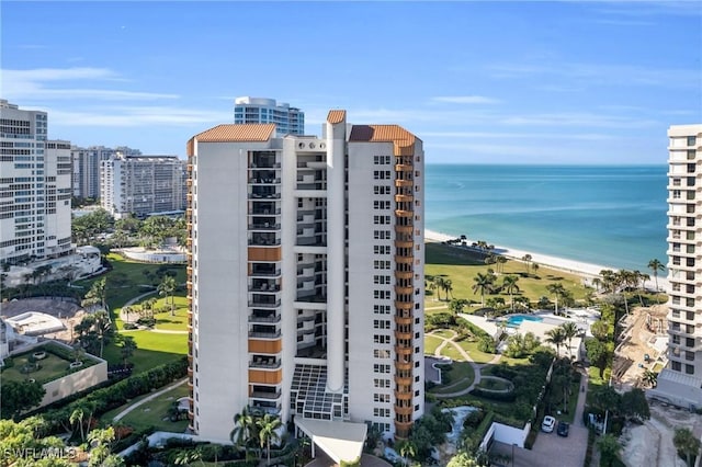 view of building exterior with a water view and a view of the beach