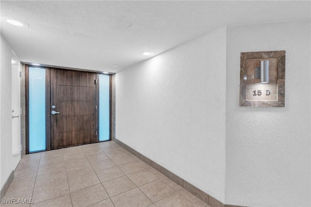 tiled entrance foyer featuring a textured ceiling