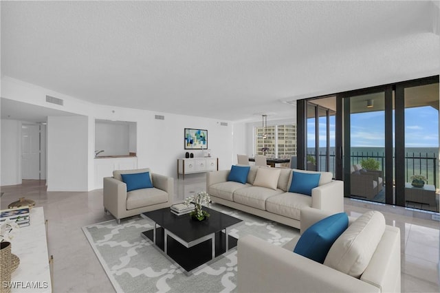 living room featuring floor to ceiling windows and a textured ceiling