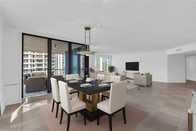 dining area with expansive windows and a chandelier