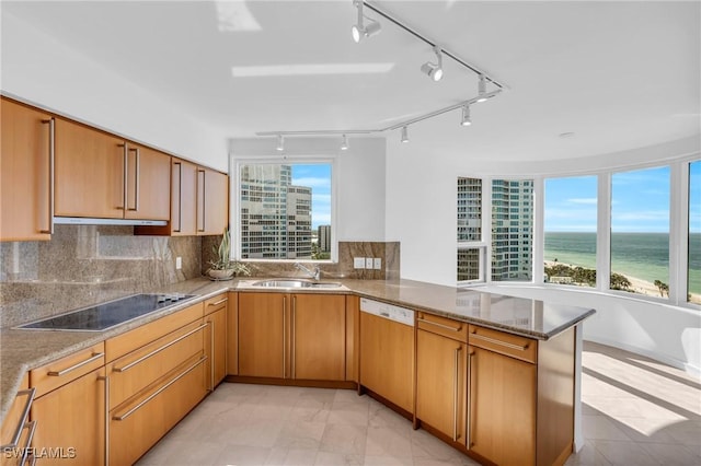 kitchen featuring dishwashing machine, sink, a water view, black electric cooktop, and kitchen peninsula