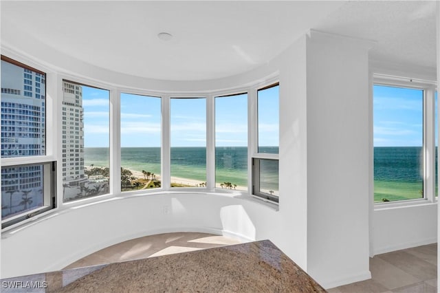 unfurnished sunroom with a water view