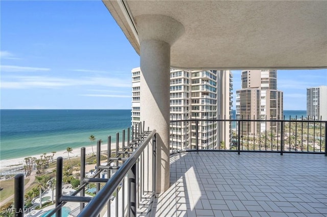 balcony featuring a water view and a view of the beach