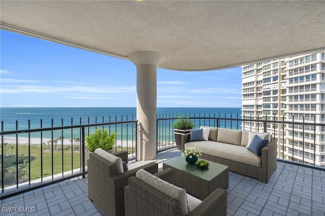 balcony featuring an outdoor living space, a water view, and a beach view