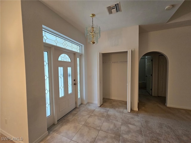 foyer entrance featuring light tile patterned floors and a chandelier