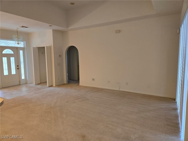 interior space featuring a towering ceiling and light colored carpet