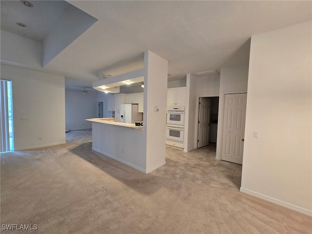 kitchen featuring white cabinetry, white appliances, light carpet, and kitchen peninsula