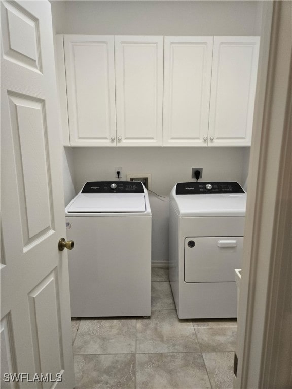 washroom featuring cabinets and washing machine and clothes dryer