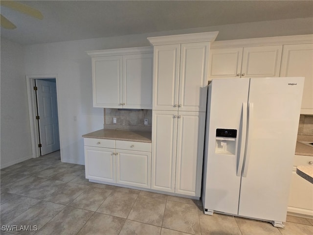 kitchen featuring white cabinetry, ceiling fan, white refrigerator with ice dispenser, and decorative backsplash