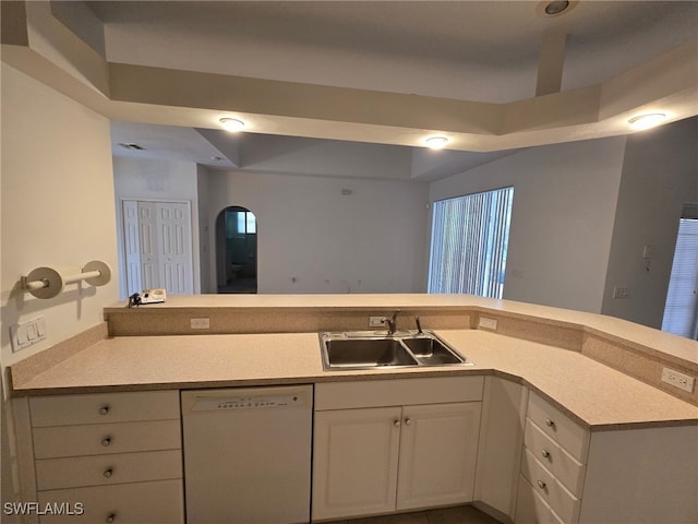 kitchen featuring white dishwasher, sink, and white cabinetry